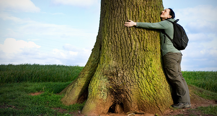 young woman hugging a big oak tree