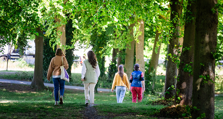 Groep mensen loopt door een zomers bos